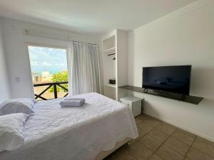 a bedroom with a bed and a flat screen tv at Breeze Hotel in Natal