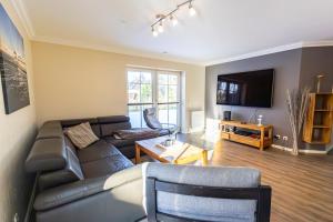 a living room with a couch and a tv at Appartement Dorfluft in Böhl