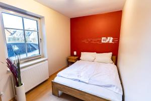 a bedroom with a bed with a red wall at Appartement Dorfluft in Böhl
