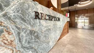 a man is standing next to a rock formation in a lobby at Solia Hotel in Mezitli