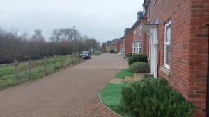 a brick street with a car parked next to a house at Serene and Cosy Private Studio in Milton Keynes