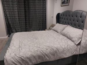 a bedroom with a large bed with a metal headboard at Serene and Cosy Private Studio in Milton Keynes