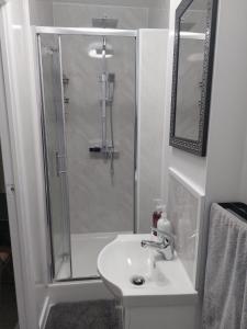 a white bathroom with a shower and a sink at Serene and Cosy Private Studio in Milton Keynes +22 photos