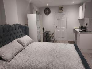 a bedroom with a large bed and a kitchen at Serene and Cosy Private Studio in Milton Keynes