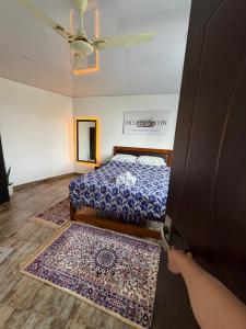 eine Person, die eine Tür zu einem Schlafzimmer mit einem Bett öffnet in der Unterkunft Baas Basai in Kalimpong