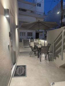 a patio with a table and chairs and an umbrella at Villa Irene in Heraklio
