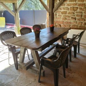 a wooden table and chairs with flowers on it at Gîte Les Copains de Maui in Baerenthal
