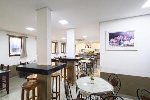 a restaurant with tables and chairs in a room at Hotel Portela II - Av Principal e a 500m do Thermas dos Laranjais in Olímpia