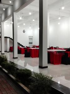 a large room with tables with red table cloth at Hotel Diamond Palace in Bibile