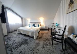 ein Schlafzimmer mit einem Bett, einem Tisch und einem Fenster in der Unterkunft Cynamon in Nowy Sącz