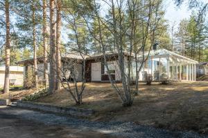 a small white house with trees in front of it at Villa Pulla - House Near Nature & City Center in Rovaniemi