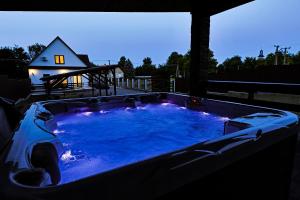 a large hot tub in a backyard with a house at Silver Cottage in Máriapócs