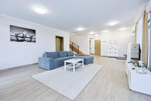 a living room with a blue couch and a table at Silver Cottage in Máriapócs