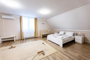 a white room with a bed and a rug at Silver Cottage in Máriapócs +43 photos
