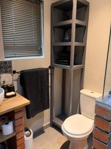 a bathroom with a white toilet in a room at Otista Self-Catering Cottage Bloemfontein in Bloemfontein +8 photos