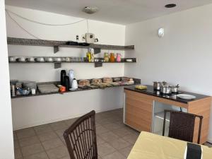 a kitchen with a table and a counter with shelves at Breeze Hotel in Natal