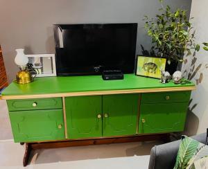 a green dresser with a television on top of it at Otista Self-Catering Cottage Bloemfontein in Bloemfontein