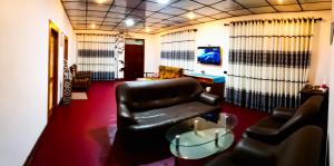 a living room with a leather chair and a table at Evergreen Resort Ella in Ella