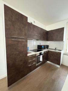 a kitchen with brown cabinets and a stove top oven at Apartment Malpensa in Somma Lombardo