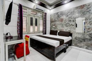 a bedroom with a bed in a room with a stone wall at Hotel O ANANT ONE HOTEL AND BANQUETS in Ghaziabad