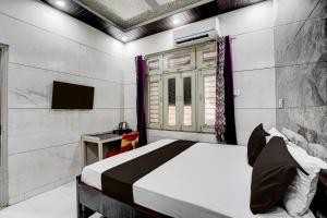 a bedroom with a bed and a window and a television at Hotel O ANANT ONE HOTEL AND BANQUETS in Ghaziabad +55 photos