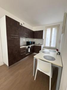 a kitchen with a white table and a white chair at Apartment Malpensa in Somma Lombardo