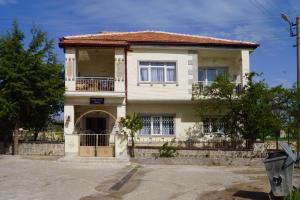 a large white house with a balcony on a street at Hibe Dede Konak in Ürgüp