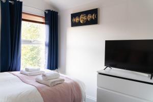a bedroom with a bed and a flat screen tv at Spacious and Comfortable - 5 Bedroom Home in Kettering +21 photos