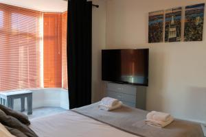 a bedroom with a bed with a flat screen tv at Spacious and Comfortable - 5 Bedroom Home in Kettering