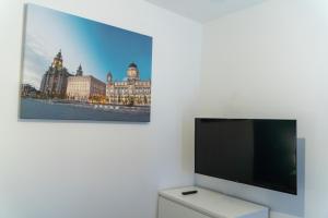 a flat screen tv on a white wall with a picture at Spacious and Comfortable - 5 Bedroom Home in Kettering