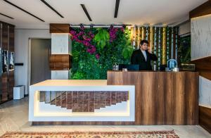 a man talking on a phone at a counter in a lobby at Hilltown Airport Hotel & Restaurant in Taşoluk