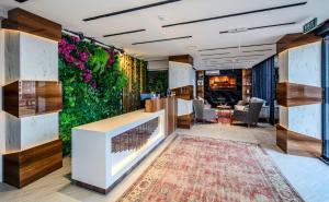 a lobby with a green wall with plants at Hilltown Airport Hotel & Restaurant in Taşoluk