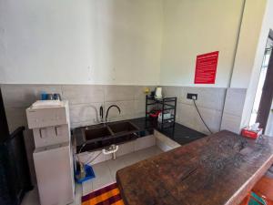 a kitchen with a wooden table and a refrigerator at Jebat D'Manggis Janda Baik - Mountain View in Bentong