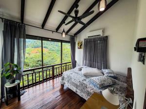 a bedroom with a bed and a large window at Jebat D'Manggis Janda Baik - Mountain View in Bentong +13 photos
