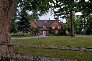 a large house with a fence in front of it at Eganridge Resort, Golf Club & Spa in Bobcaygeon