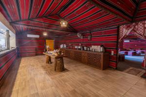 a restaurant with red walls and a table in a room at Aladdin Camp in Disah