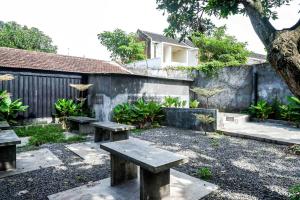 a garden with benches and a wall at RedDoorz Plus @ Kalpataru in Rampal