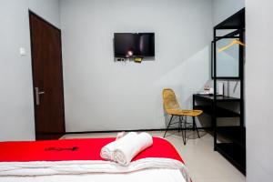 a bedroom with a bed and a tv on the wall at RedDoorz Plus @ Kalpataru in Rampal