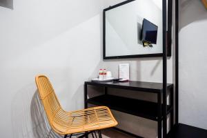 a desk with a chair and a television in a room at RedDoorz Plus @ Kalpataru in Rampal