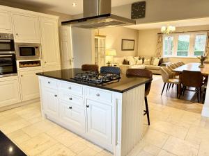 a kitchen with a stove top island in a room at Willow Brook in Glossop