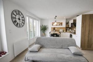 a living room with a couch and a clock on the wall at Au dôme de la basilique in Boulogne-sur-Mer