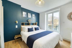 a bedroom with a large bed with a blue wall at Au dôme de la basilique in Boulogne-sur-Mer