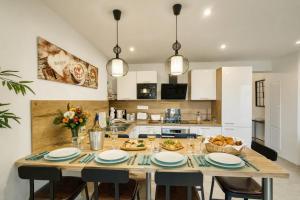 a kitchen with a large wooden table with chairs and a table sidx sidx at Au dôme de la basilique in Boulogne-sur-Mer