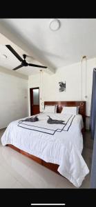 a bedroom with a large bed with a ceiling fan at Green Corner VILLA in Bukit Lawang