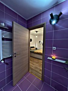a room with purple walls and a ceiling fan at VerdeViu Apartments 2 Prima Green Residence in Oradea +5 photos