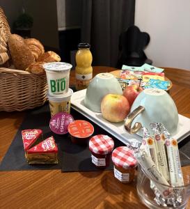 a table with a tray of food with apples and bread at La Tour Grégoire in Clermont-Ferrand