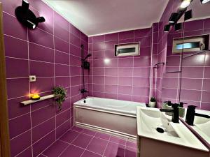 a purple bathroom with a tub and a sink at VerdeViu Apartments 2 Prima Green Residence in Oradea