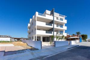 a white apartment building in front of a blue sky at BlueBell Limassol Suites in Limassol