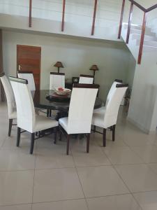 ein Esszimmer mit einem Tisch und weißen Stühlen in der Unterkunft Ibokwe homested in Hillandale