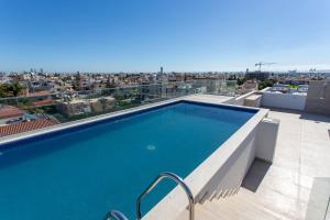 a swimming pool on the roof of a building at BlueBell Limassol Suites in Limassol